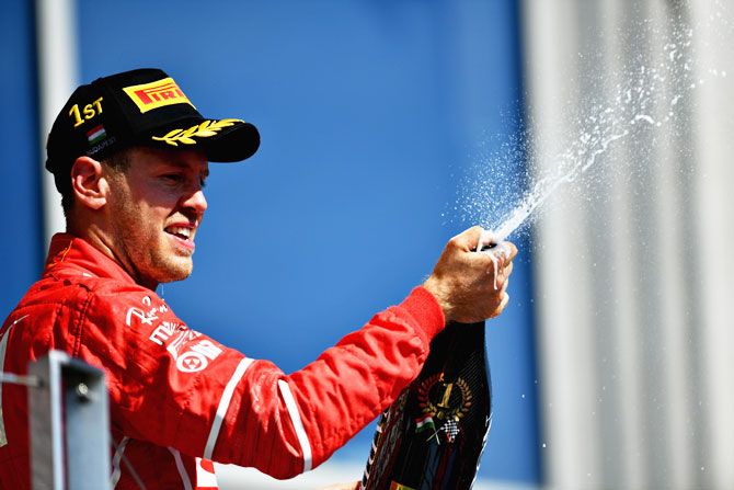 Ferrari's German driver Sebastian Vettel celebrates on the podium after winning the Hungarian Formula One Grand Prix at Hungaroring on Sunday