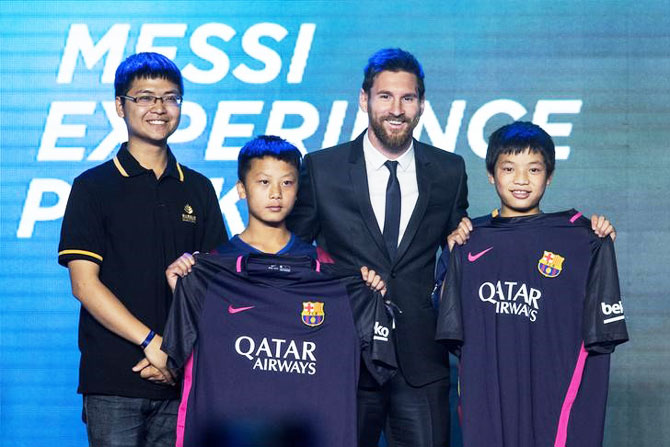 Argentine soccer player Lionel Messi poses with young fans as he attends a news conference in Beijing, China on Thursday