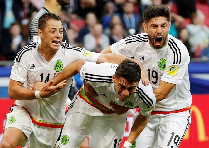 Mexico’s Hector Moreno celebrates with Javier Hernandez and Oribe Peralta after scoring the late equaliser against Portugal on Sunday