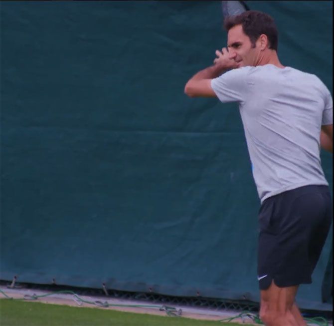Roger Federer hits during a training session