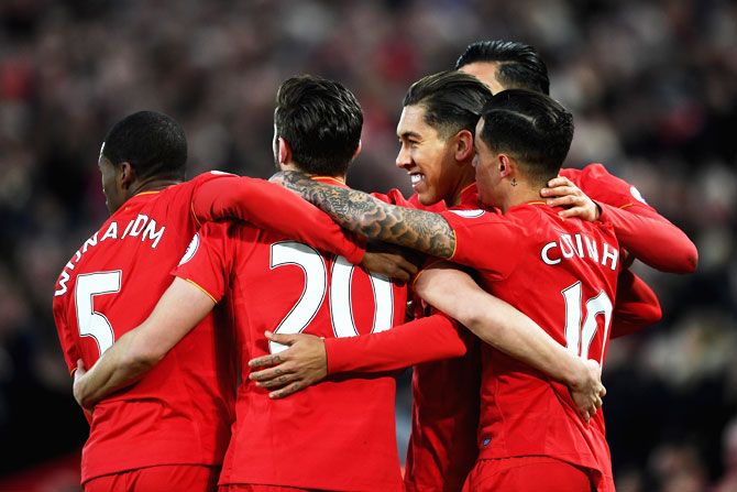  Liverpool's Roberto Firmino (right) celebrates with teammates on scoring his side's first goal against Arsenal during their Premier League match at Anfield in Liverpool on Saturday