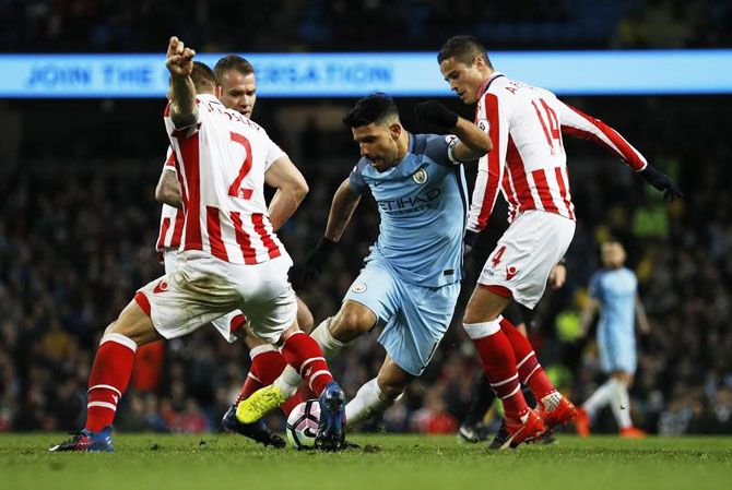 Manchester City's Sergio Aguero is challenged by Stoke City's Ibrahim Affelay and Phil Bardsley