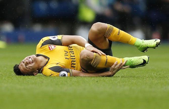 Arsenal's Alexis Sanchez grimaces in pain as he goes down with an injury