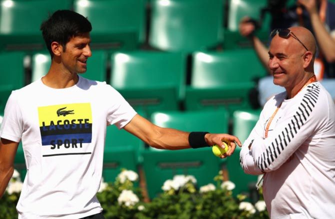 : Novak Djokovic speaks to his coach Andre Agassi ahead of his second round match against Joao Sousa