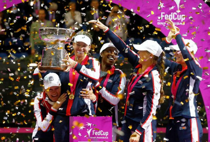 Members of the US team celebrate with the trophy after defeating Belarus in the Fed Cup Final on Sunday
