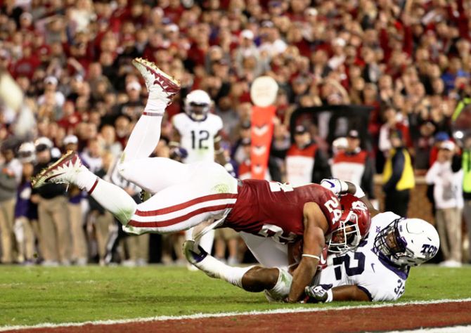 Oklahoma Sooners running back Rodney Anderson runs over TCU Horned Frogs linebacker Travin Howard for a touchdown during their NCAA Football tournament on Sunday