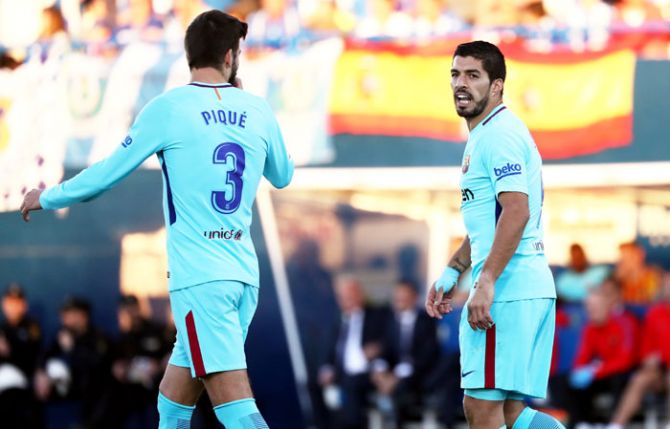Gerard Pique and Luis Suarez (right) received cards during their La Liga match against Leganes on Saturday
