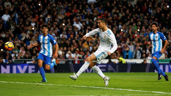 Real Madrid’s Cristiano Ronaldo scores their third goal, which is a rebound from a penalty miss during their La Liga match against Malaga at the Santiago Bernabeu in Madrid on Saturday