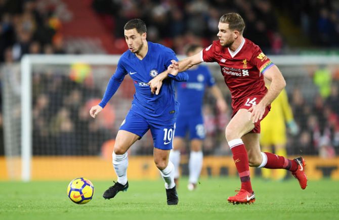 Chelsea's Eden Hazard is challenged by Liverpool's Jordan Henderson as they battle for possession during their English Premier League match at Anfield in Liverpool, England on Saturday
