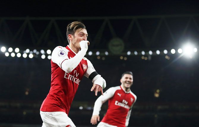 Arsenal's Mesut Ozil celebrates after scoring his side's fourth goal against Huddersfield Town at Emirates Stadium in London