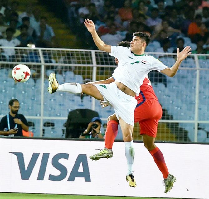 A player from Iraq and a Chile player compete for the ball during their FIFA U-17 World Cup match in Kolkata on Wednesday