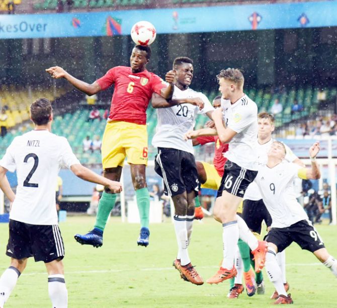 Players of Guinea and Germany (white) vie for an aeriel ball during their U-17 FIFA World Cup football match at Jawaharlal Nehru International Stadium in Kochi on Friday