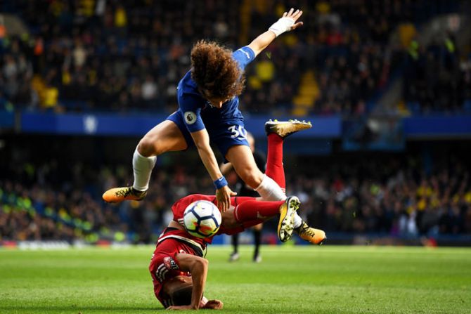 Watford's Richarlison de Andrade takes a tumbles as he is tackled by Chelsea's David Luiz while they vie for possession during their English Premier League match at Stamford Bridge in London on Saturday