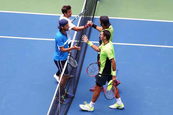 Jean-Julien Rojer and Horia Tecau are congratulated by Feliciano Lopez and Marc Lopez