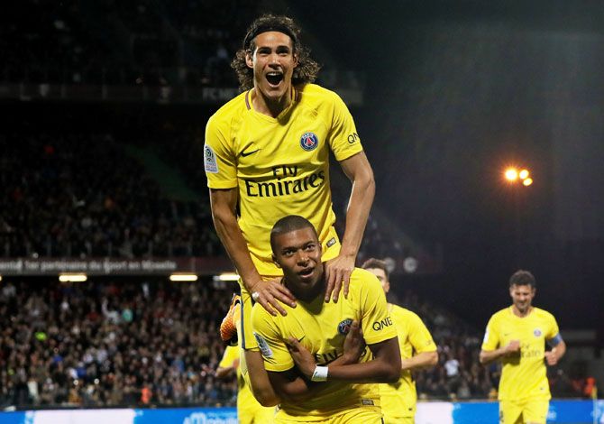 Paris Saint-Germain’s Kylian Mbappe celebrates scoring their second goal with Edinson Cavani during their Ligue 1 match against FC Metz on Friday