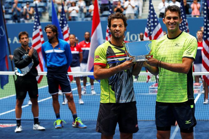 Champions Jean-Julien Rojer of the Netherlands (left) and Horia Tecau of Romania hold up the trophy after defeating Spainish duo Feliciano Lopez and Marc Lopez