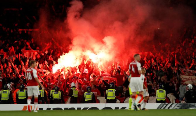 FC Koln fans celebrate their first goal by letting off flares during the Europa League match against Arsenal at Emirates Stadium in London on Thursday