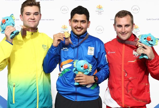 From left, silver medallist Sergei Evglevski of Australia, gold medallist Anish of India and bronze medallist Sam Gowin of England pose during the medal ceremony for the 25m Rapid Fire Pistol