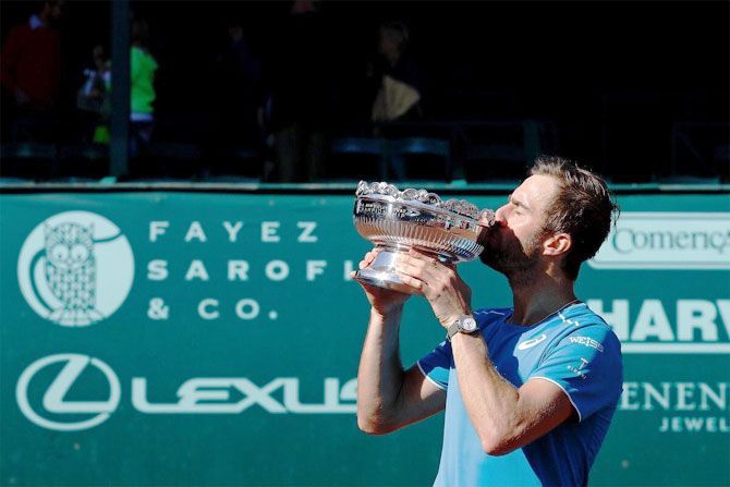 USA's Steve Johnson celebrates with the trophy after winning the Houston Clay Court Championships on Sunday
