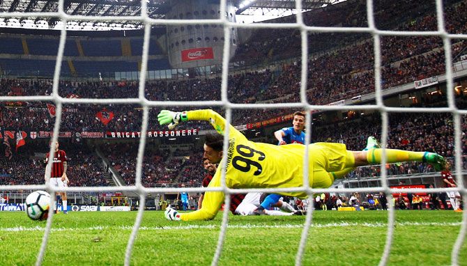 AC Milan's Gianluigi Donnarumma saves a shot from Napoli's Arkadiusz Milik