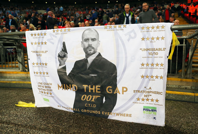A banner bearing a picture of Manchester City manager Pep Guardiola dressed as James Bond during the Premier League match between Tottenham Hotspur and Manchester City at Wembley Stadium in London on Saturday