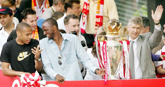 Arsenal's Thierry Henry, Patrick Viera and manager Arsene Wenger celebrate their EPL title-win during a victory parade in north London on May 16, 2004