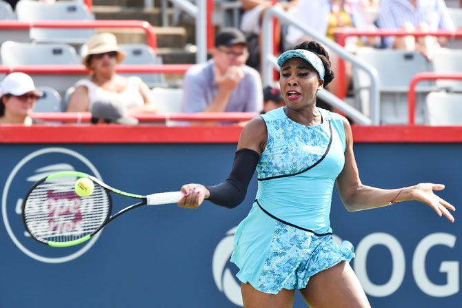 Venus Williams hits a return during her Rogers Cup match against Caroline Dolehide at IGA Stadium in Montreal, Quebec, Canada, on Monday
