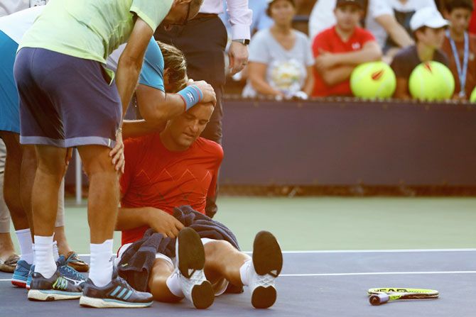 Russia's Mikhail Youzhny lays on the court while suffering from heat exhaustion during his men's singles first round match against Marcos Baghdatis of Cyprus on Tuesday
