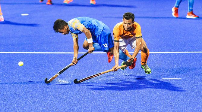 India's Vivek Prasad (left) and a Malaysian player in action during the men's hockey semi-final match at the 18th Asian Games 2018, in Jakarta, Indonesia on Thursday