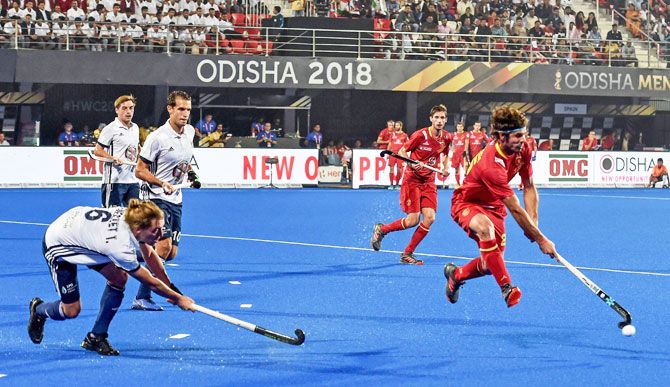 A Spain player runs past France's Tom Genestet (6) during their Men's Hockey World Cup match in Bhubaneswar on Monday