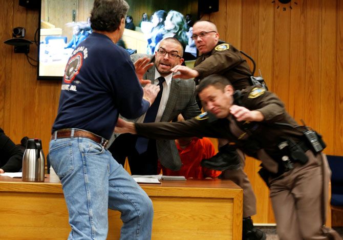 Randall Margraves (left) lunges at Larry Nassar, (wearing orange) a former team USA Gymnastics doctor who pleaded guilty in November 2017 to sexual assault charges, during victim statements of his sentencing in the Eaton County Circuit Court in Charlotte, Michigan, USA, on Friday