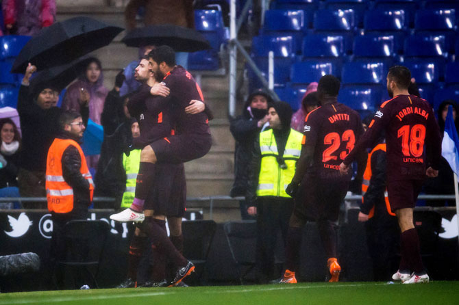 FC Barcelona's Gerard Pique celebrates with teammates after scoring his team's first goal during their La Liga match against Espanyol at RCDE Stadium in Barcelona on Sunday