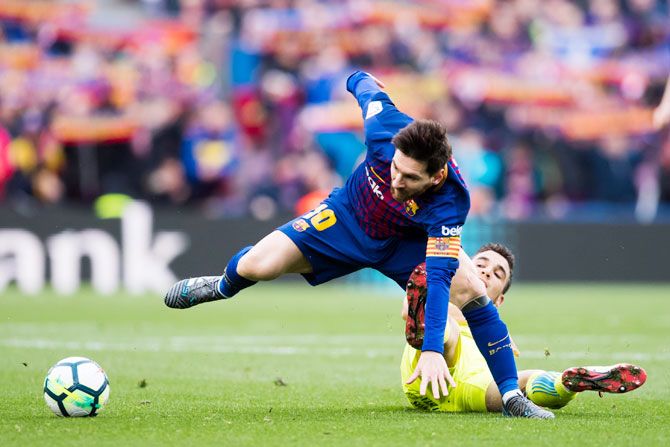 Getafe CF'S Mauro Arambarri tackles FC Barcelona's Lionel Messi during their La Liga match at Camp Nou in Barcelona on Sunday