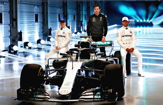 (Left to right) Mercedes GP's Finnish driver Valtteri Bottas, Mercedes GP's Executive Director Toto Wolff and Mercedes GP's British driver Lewis Hamilton pose during the launch of the Mercedes W09 car, at Silverstone Circuit in Northampton, England, on Thursday