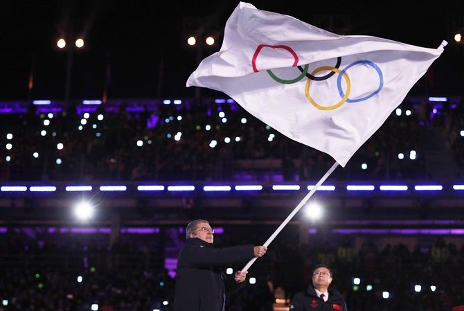 IOC President Thomas Bach waves the Olympic flag during the closing ceremony