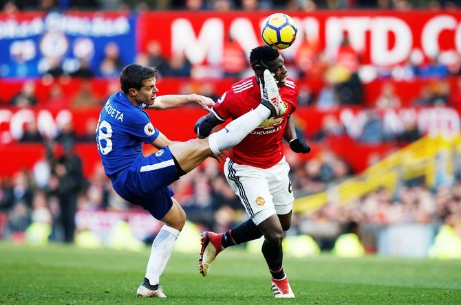 Manchester United's Paul Pogba takes evasive action to avoid getting booted by Chelsea's Cesar Azpilicueta while they vie for possession