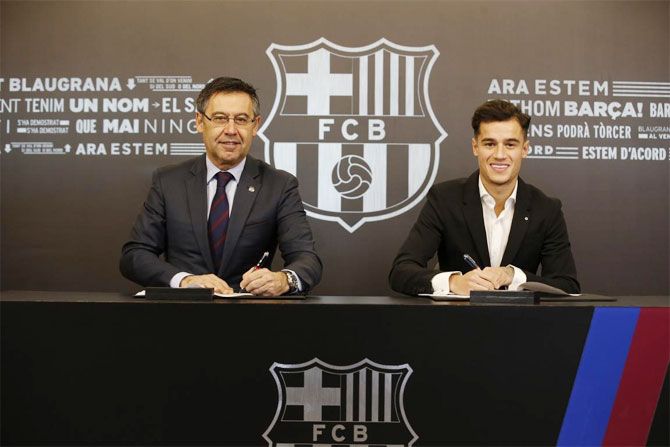 FC Barcelona's new record signing Philippe Coutinho (right) puts pen on paper in presence of club president Josep Maria Bartomeu on Monday