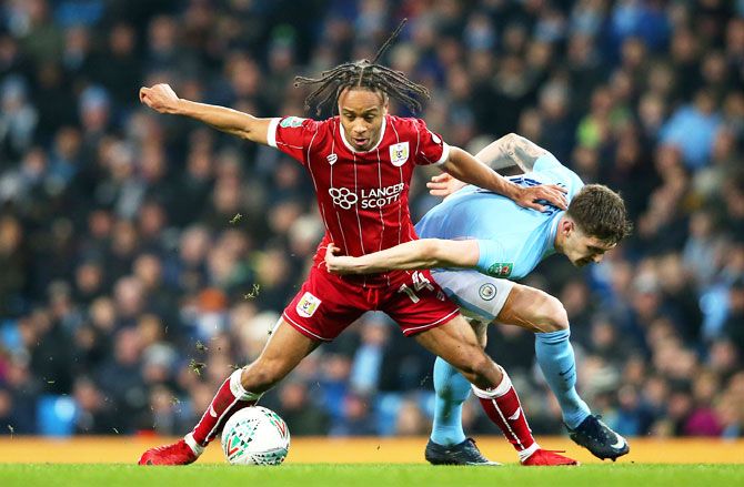 Bristol City' Bobby Reid holds off a challenge by Manchester City's John Stones