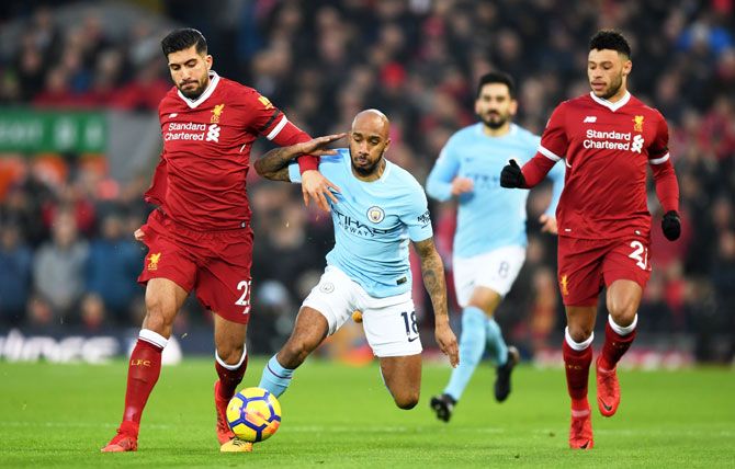 Liverpool's Emre Can and Manchester City's Fabian Delph vie for possession as Liverpool's Alex Oxlade-Chamberlain watches