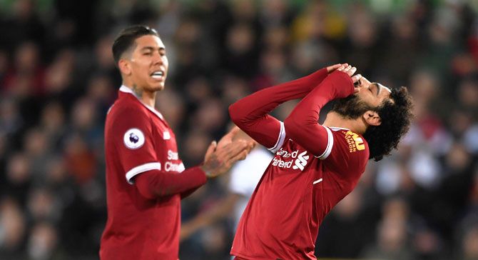 Liverpool's Mohamed Salah reacts after missing a chance as teammate Roberto Firmino (left) looks on