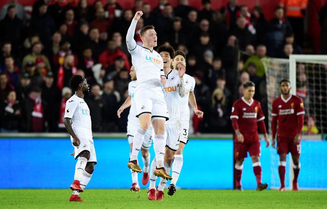 Swansea City's Alfie Mawson celebrates scoring their first goal against Swansea City at Liberty Stadium in Swansea on Monday