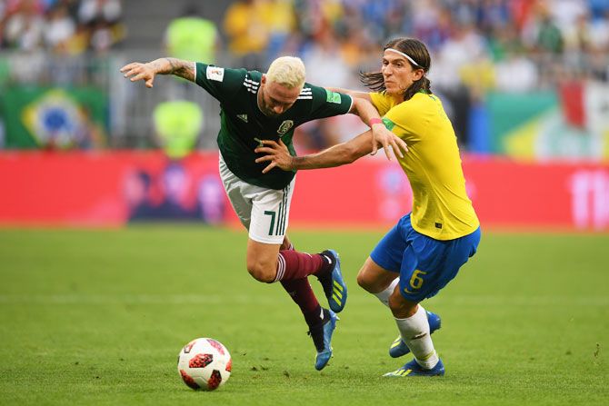 Mexico's Miguel Layun is tackled by Brazil's Filipe Luis 