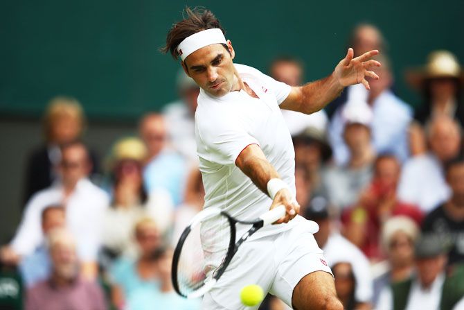 Switzerland's Roger Federer returns against Slovakia's Lukas Lacko during their second round match on day three of the Wimbledon Lawn Tennis Championships at All England Lawn Tennis and Croquet Club in London on Wednesday