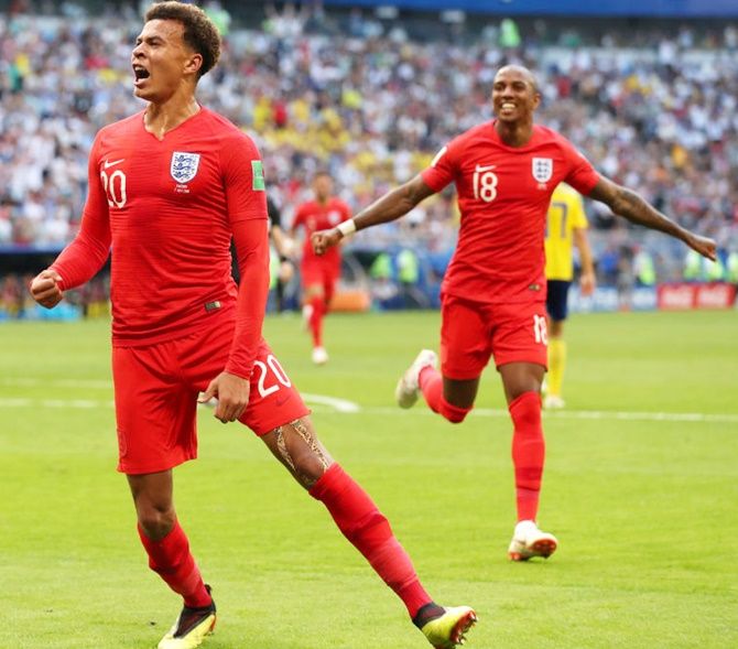 Dele Alli of England celebrates after scoring his team's second goal with teammate Ashley Young