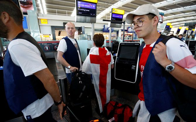 England football fans prepare to depart to Moscow for England's semi-final at the World Cup at Heathrow Airport in London on Tuesday