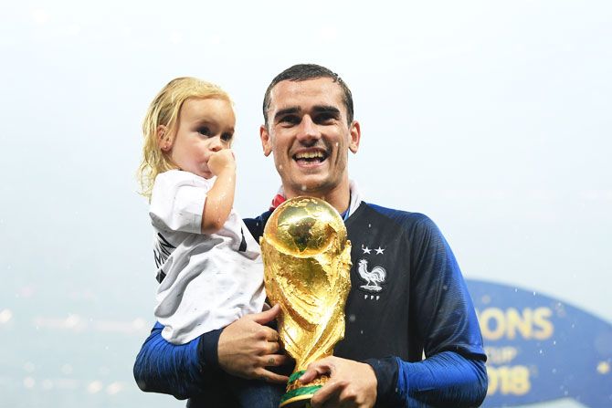 France's Antoine Griezmann celebrates victory with daughter Mia and the World Cup trophy