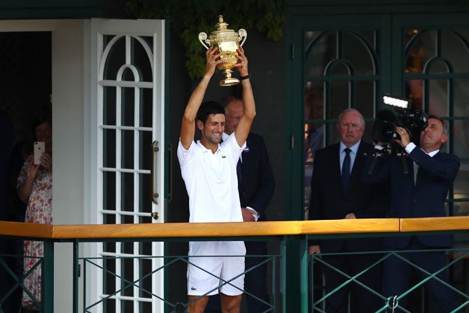 Novak Djokovic lifts the trophy on the balcony of Centre Court after winning the men's singles final against Kevin Anderson on day thirteen of the Wimbledon Lawn Tennis Championships at All England Lawn Tennis and Croquet Club in London, England, on Sunday