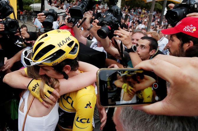 Team Sky rider Geraint Thomas of Britain, wearing the overall leader's yellow jersey, celebrates with his wife Sara Elen Thomas after the finish at the 116-km Stage 21 from Houilles to Paris Champs-Elysees on Sunday