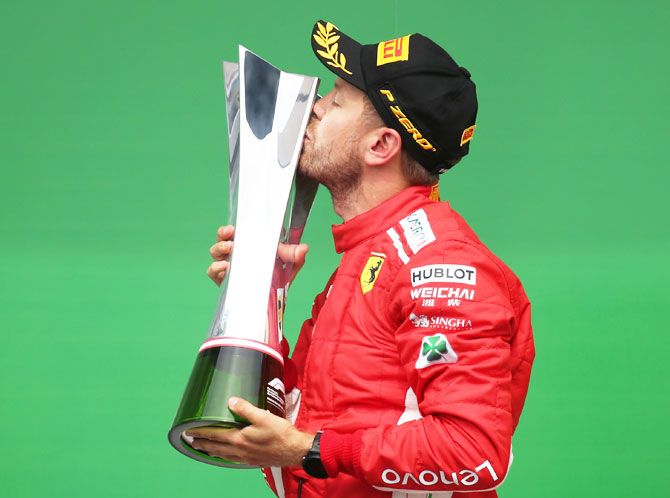 Ferrari's Sebastian Vettel kisses the trophy after winning the race