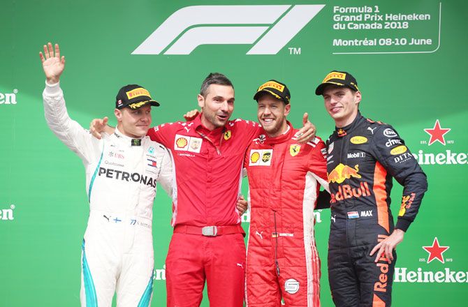 Ferrari's Sebastian Vettel celebrates winning the race on the podium with second placed Mercedes' Valtteri Bottas and third placed Red Bull's Max Verstappen 